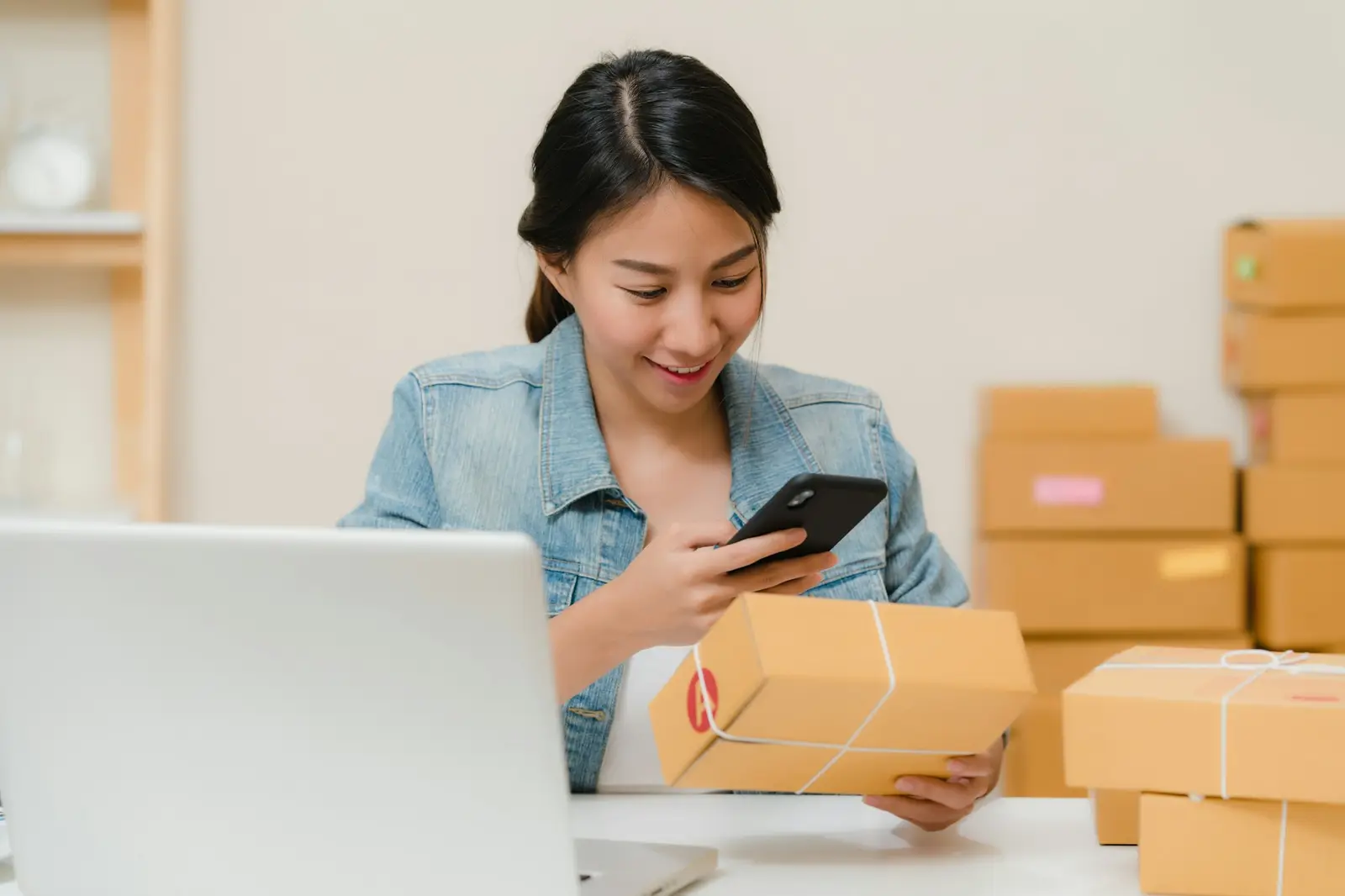 A client checking a parcel's details on her phone at her desk