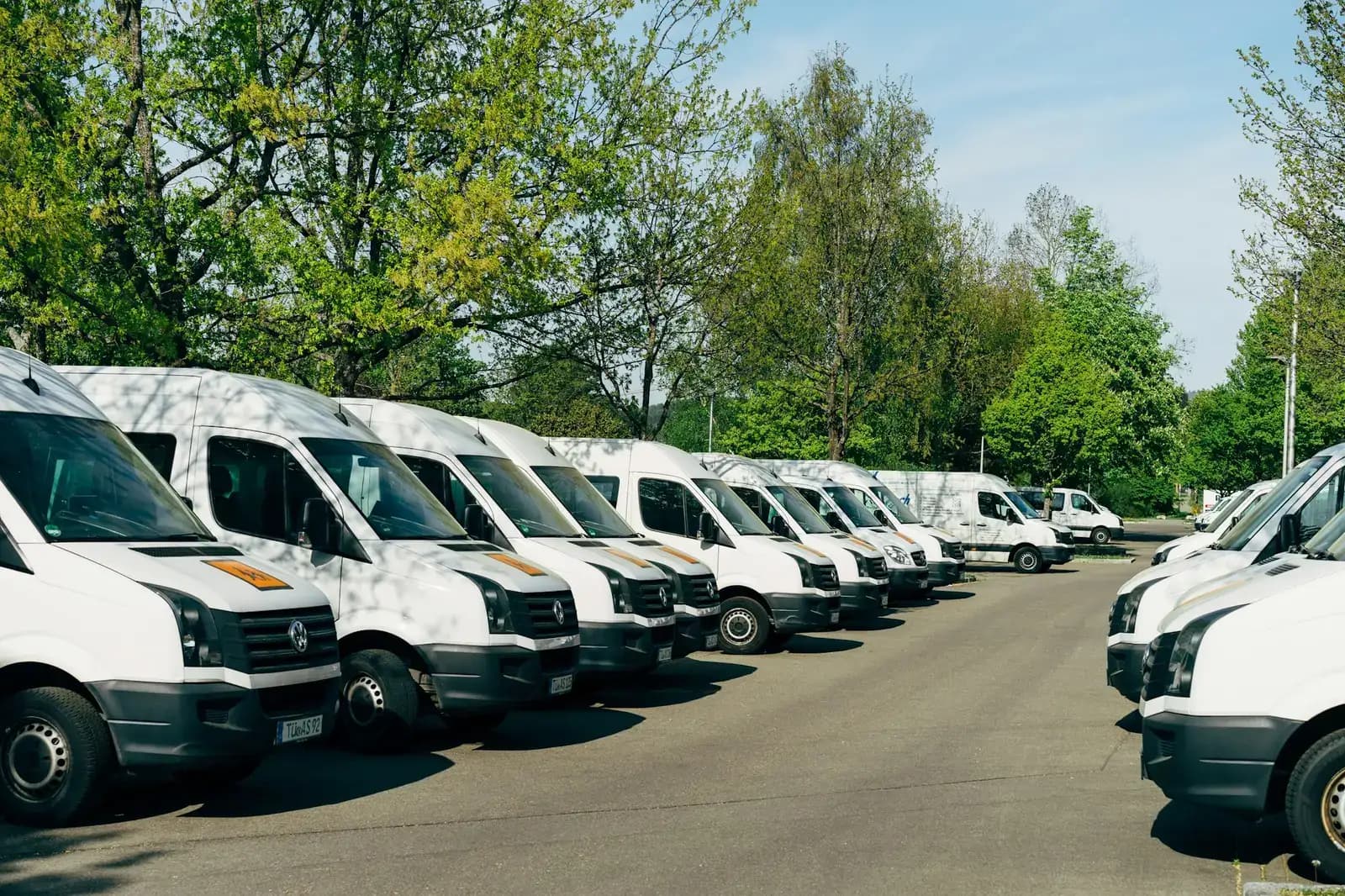 A row of white courier vans parked at a depot